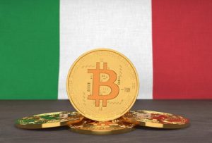 Monete digitali con il simbolo del Bitcoin posizionate davanti alla bandiera italiana, rappresentando la crescente diffusione e l’interesse per le criptovalute in Italia.