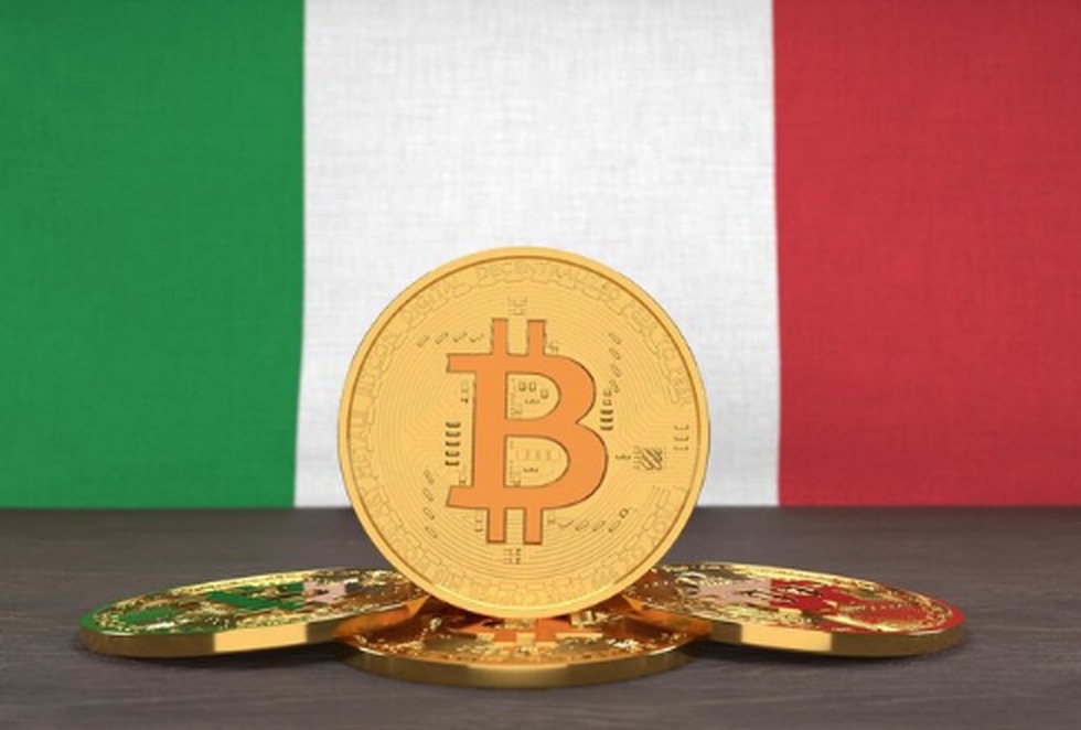 Monete digitali con il simbolo del Bitcoin posizionate davanti alla bandiera italiana, rappresentando la crescente diffusione e l’interesse per le criptovalute in Italia.