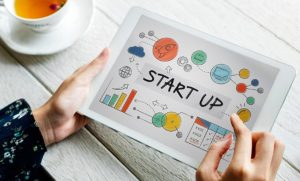 Persona che utilizza un tablet con una schermata illustrata dedicata a un progetto di business, simbolo della crescita e innovazione del settore delle startup in Italia.