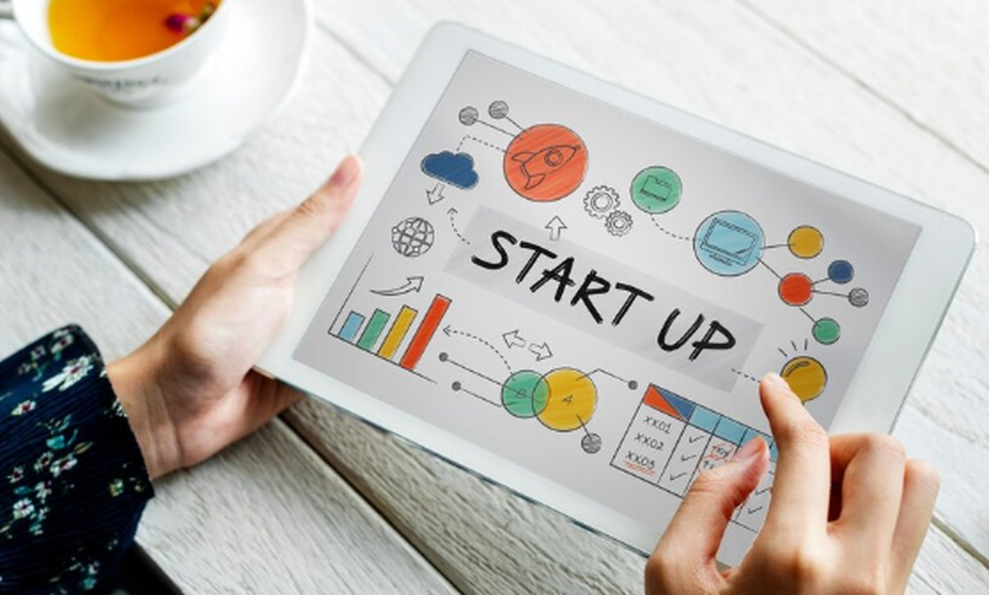 Persona che utilizza un tablet con una schermata illustrata dedicata a un progetto di business, simbolo della crescita e innovazione del settore delle startup in Italia.