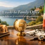 Immagine illustrativa sul ruolo dei family office in Italia per investitori ad alto patrimonio. In primo piano, su una scrivania in legno lucido, si trovano un mappamondo dorato, una piccola casa in legno appoggiata su alcuni libri rilegati, un orologio elegante con cinturino in pelle, una penna stilografica, un mazzo di chiavi e un paio di occhiali sopra alcuni documenti. Sullo sfondo si vede un paesaggio lacustre con montagne e una villa italiana affacciata sull’acqua, mentre sulla destra compare la bandiera italiana. In alto è presente il titolo: “Il ruolo dei Family Office in Italia per gli investitori ad alto patrimonio”. Non sono presenti persone reali nell’immagine.